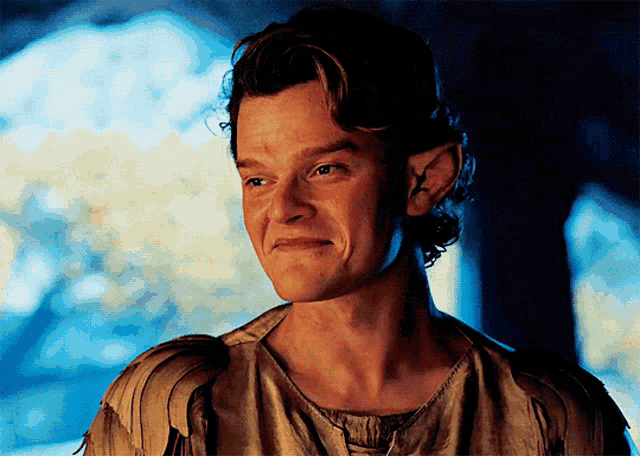 a close up of a man with elf ears making a face