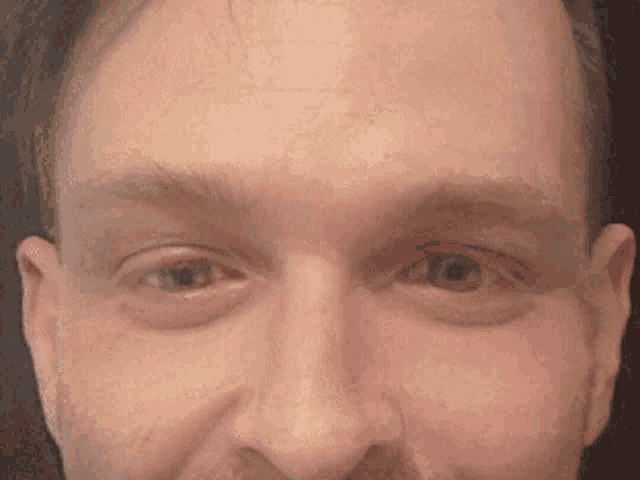 a close up of a man 's face with his eyes open