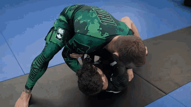 a man wearing a green shirt that says jiu-jitsu