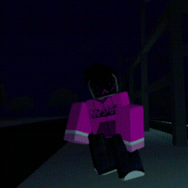 a person in a pink hoodie is standing in a dark room .