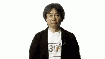 a man is standing in front of a mario maker 3ds game