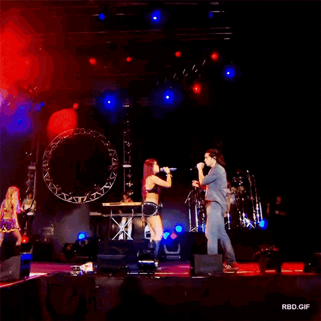 a man and a woman singing on a stage with a rbd.gif watermark