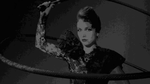 a black and white photo of a woman holding a microphone .