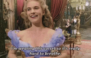 a woman is wearing a purple corset and smiling .
