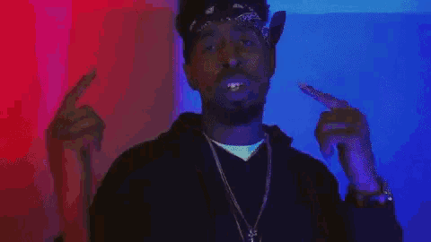 a man wearing a bandana and a necklace is standing in front of a colorful background .