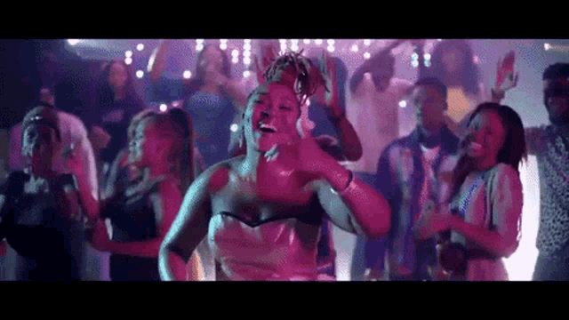a woman is dancing in front of a crowd of people at a party .