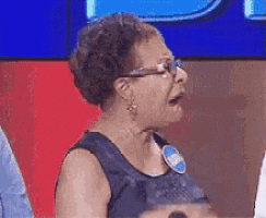 an older woman wearing glasses and a name tag that says ' sally ' on it