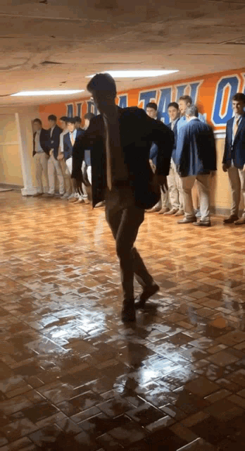a man in a suit and tie is dancing in front of a wall that says u.s. army
