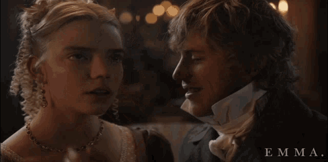 a man and a woman are standing next to each other and the word emma is on the bottom right