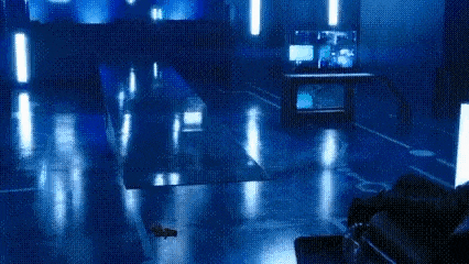 a person in a futuristic suit is riding a robot in a dark room .