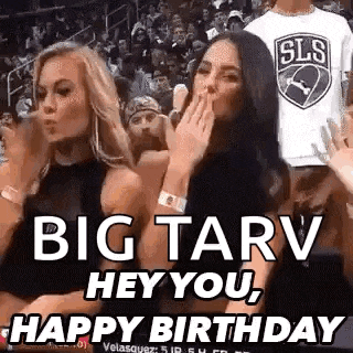 two women are sitting in the stands at a basketball game and one of them is blowing a kiss to the other .