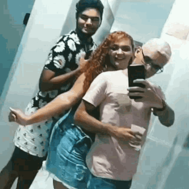 a man is taking a selfie with a woman and a man is holding a woman in his arms .