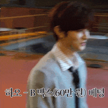a blurry picture of a man in a suit and tie with korean writing