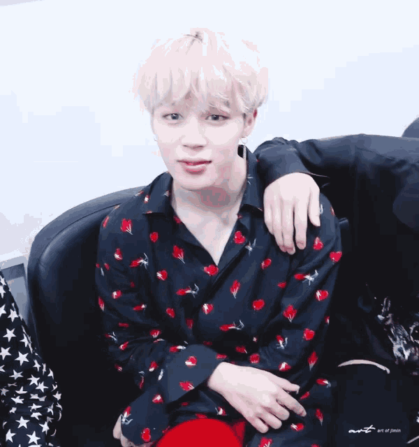 a man in a black shirt with red flowers on it