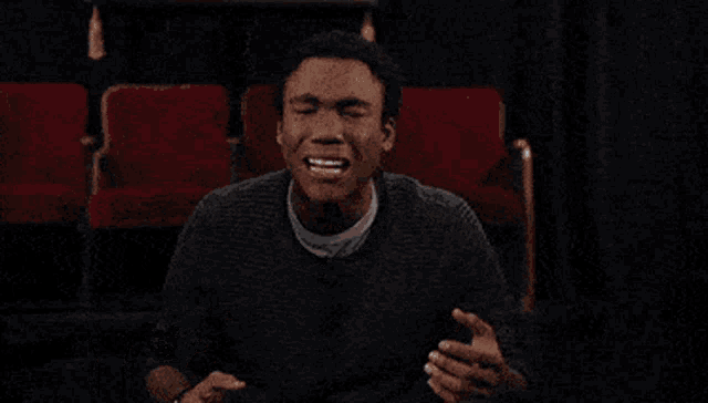 a man sitting in a theater with the words " my emotions " on the bottom