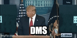 a man in a suit and tie is standing in front of a podium with the word dms on it