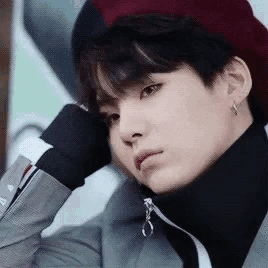 a close up of a person wearing a hat and turtleneck