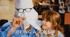 a man wearing glasses and a paper mask is holding a little girl .