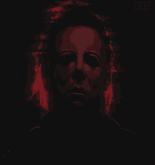 a man 's face is shown in a dark room with the letters btf below him