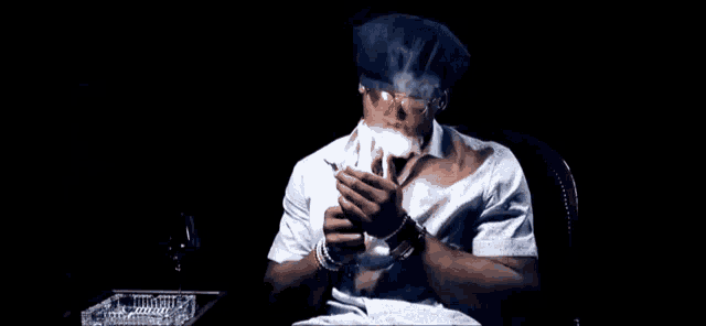 a man is smoking a cigar in a dark room