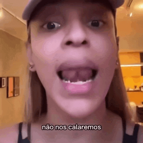 a close up of a woman 's face with her mouth open and the words `` não nos calaremos '' written on the bottom .