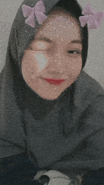 a woman wearing a hijab with purple bows in her hair