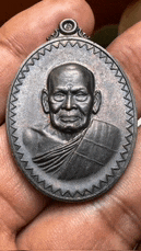 a person is holding a coin with a picture of a monk on it