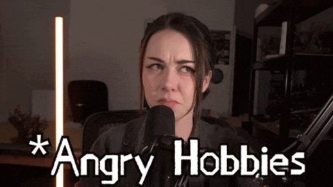 a woman is sitting in front of a microphone with the words `` angry hobbies '' written on the bottom .