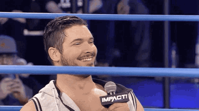 a man in a ring with a microphone that says impact