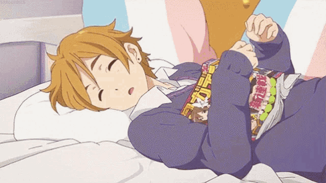 a boy is laying on a bed with a magazine on his chest that says ' tokyo ghoul ' on it