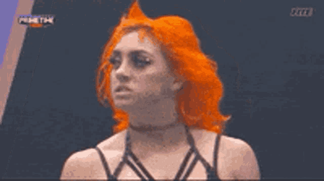 a woman with red hair is standing in front of a sign that says wwe