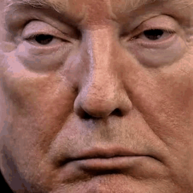 a close up of donald trump 's face with a serious expression on his face .