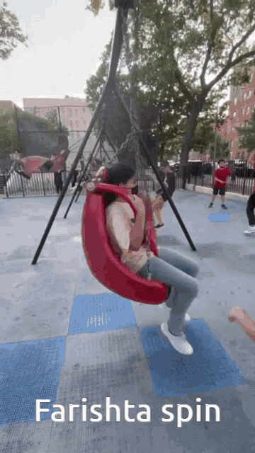 a woman is sitting on a red swing with the words farishta spin below her