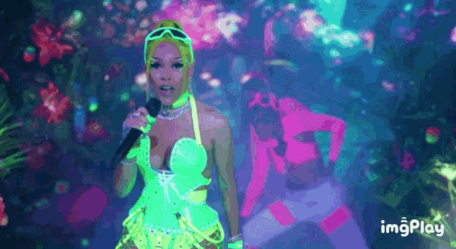 a woman in a neon outfit is singing into a microphone ..