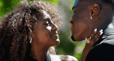 a man and a woman are looking at each other and the woman has a nose ring on her nose
