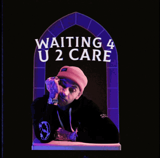a man in a pink hat is sitting in front of a sign that says waiting 4 u2 care