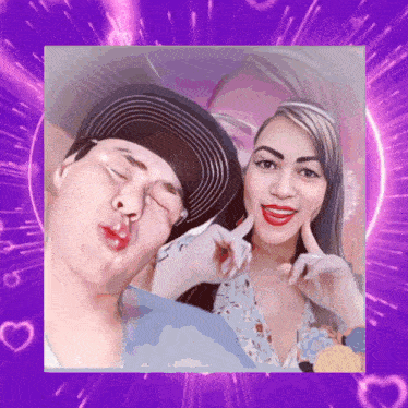 a man and a woman are posing for a picture with purple hearts in the background