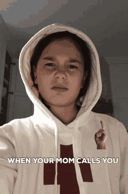 a girl wearing a white hoodie with the words " when your mom calls you " on it