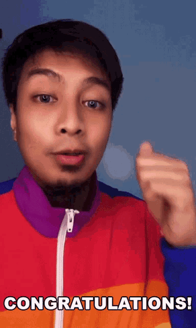 a man in a colorful jacket says congratulations with his fist in the air