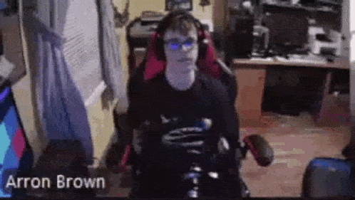 a young man is sitting in a gaming chair wearing headphones .