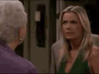 an elderly woman in a purple suit and earrings is making a funny face .