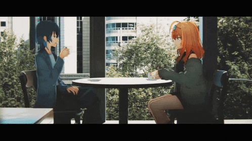 a man and a woman sit at a table talking