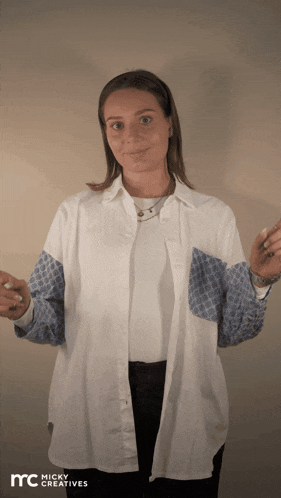 a woman wearing a white shirt with blue sleeves is standing in front of a micky creatives ad