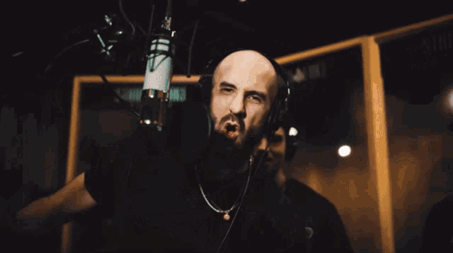 a man wearing headphones stands in front of a microphone with a sign that says sirius