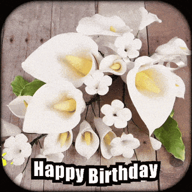 a happy birthday card with white flowers on a wooden background