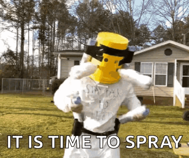 a man wearing a yellow mask is spraying something in front of a house with the words " it is time to spray "