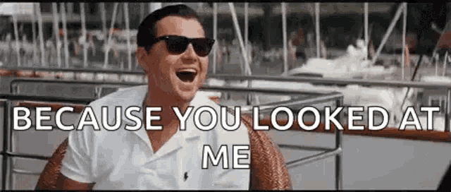 a man wearing sunglasses is sitting in a chair with his mouth open and says `` because you looked at me '' .