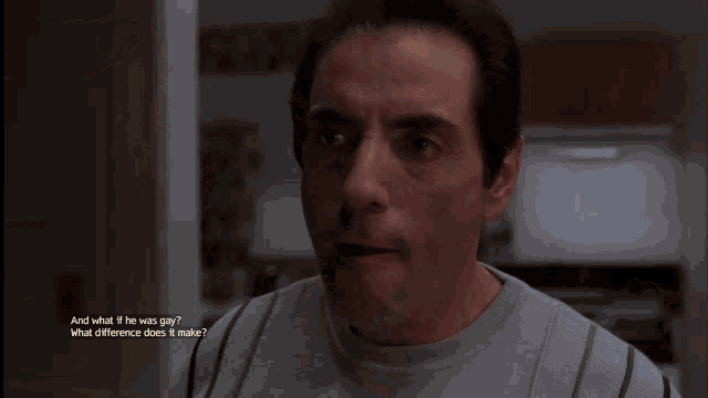 a man in a grey shirt looks at the camera