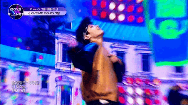 a man is dancing on a stage in front of a boys planet sign