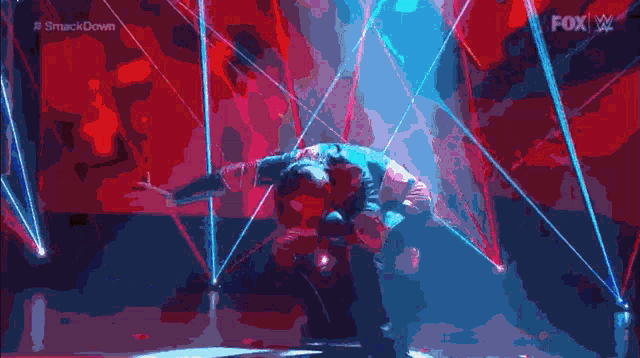 a man is kneeling down on a stage with a fox w logo in the background